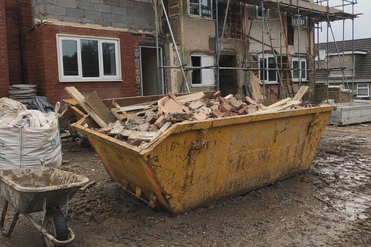 Yellow 8-yard builders skip filled with brick rubble and timber on a Scarborough renovation site